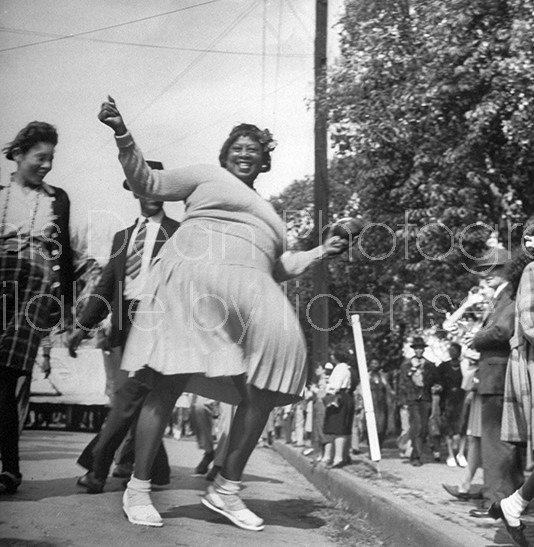 African American woman joyfully dancing during zulu parade during Mardi Gras.