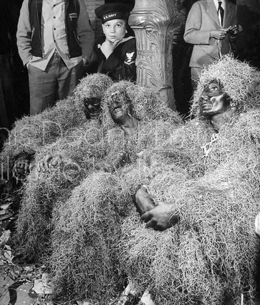Three African Americans , covered in Spanish moss during Mardi Gras.