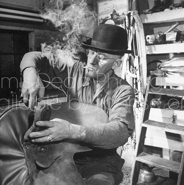 A worker for the circus fixing a saddle in his workshop.