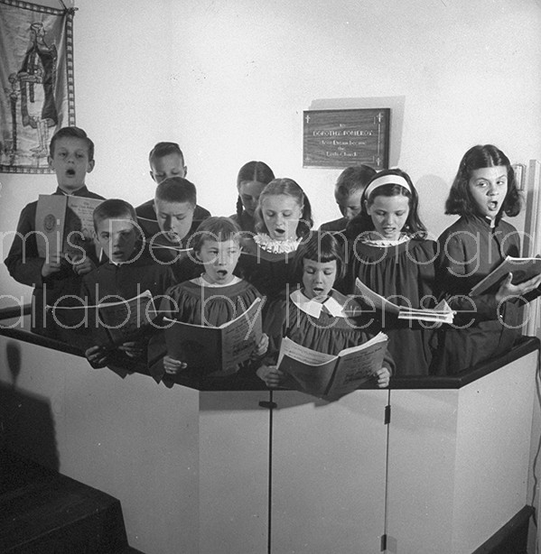 Children's chior singing during service in their minature church.