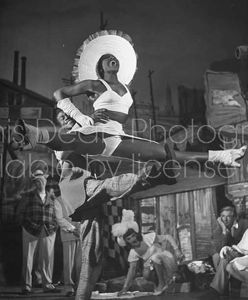 Two members of the chorus the play "Beggar's Holiday" performing gymnastics.