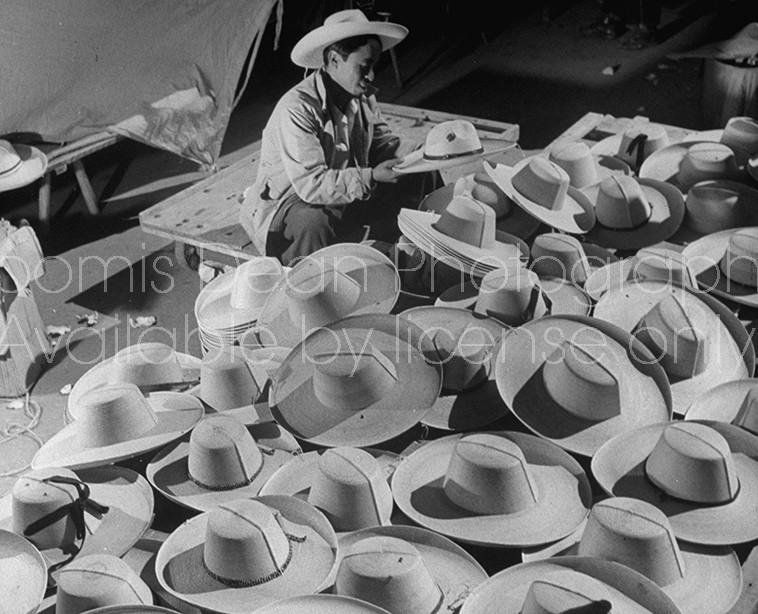 A hat vendor working among his wares at the market.