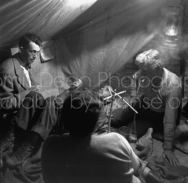 Director of "The Treasure of the Sierra Madre" John Huston (L) with the film's actors Humphrey Bogart (C, lying down) and his father Walter Huston as they talk inside of lamplit tent.