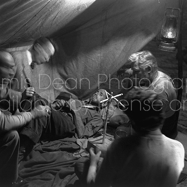 Director of "The Treasure of the Sierra Madre" John Huston (L) with the film's actors Humphrey Bogart (C, lying down), his father Walter Huston and two unident. others as they talk inside of lamplit tent.