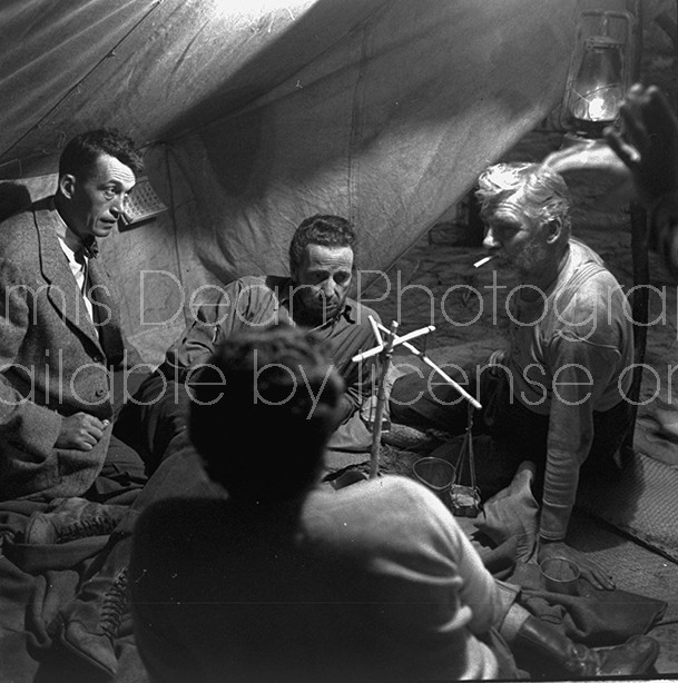 Director of "The Treasure of the Sierra Madre" John Huston (L) with the film's actors Humphrey Bogart (C), his father Walter Huston and unident. other as they talk inside of lamplit tent.