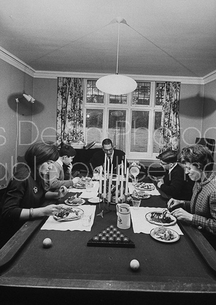 Shepherd Mead (L), satiric American author of book "How to Live Like a Lord Without Really Trying", dining on a billiard table with his family.