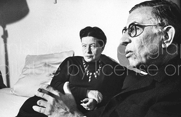 Writer Simone de Beauvoir chatting with close friend, playwright Jean Paul Sartre in her Paris apartment.