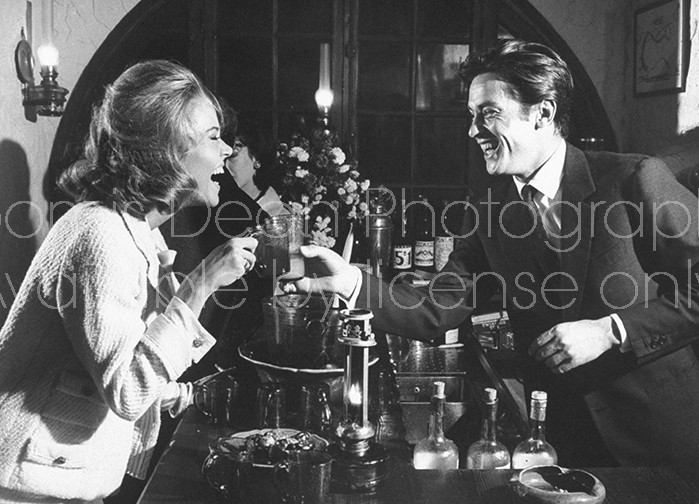 Actor Alain Delon (R) having a drink with actress Jane Fonda.