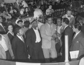 Boxer Joe Louis talking with patrons at his restaurant.