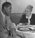 Boxer Joe Louis talking with patron at his restaurant.