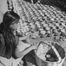 A young woman arranging her pottery for sale in the Toluca Market.