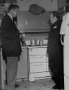 (L-R) Actors Vincent Price and Thomas Mitchell talking in a kitchen.