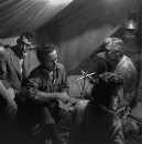 Director of "The Treasure of the Sierra Madre" John Huston (2L) with the film's actors Humphrey Bogart (C) and his father Walter Huston (R) and two unident. others as they talk inside of lamplit tent.