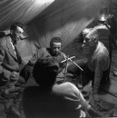 Director of "The Treasure of the Sierra Madre" John Huston (L) with the film's actors Humphrey Bogart (C), his father Walter Huston and unident. other as they talk inside of lamplit tent.