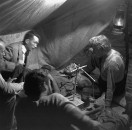 Director of "The Treasure of the Sierra Madre" John Huston (L) with the film's actors Humphrey Bogart (C), his father Walter Huston and two unident. others as they talk inside of lamplit tent.