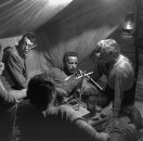 Director of "The Treasure of the Sierra Madre" John Huston (L) with the film's actors Humphrey Bogart (C), his father Walter Huston and two unident. others as they talk inside of lamplit tent.