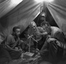 Director of "The Treasure of the Sierra Madre" John Huston (R) with the film's actors Humphrey Bogart (L) and his father Walter Huston (C), as they talk inside of lamplit tent while testing handmade scale.