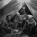Director of "The Treasure of the Sierra Madre" John Huston (R) with the film's actors Humphrey Bogart (L) and his father Walter Huston (C), as they talk inside of lamplit tent while testing handmade scale.