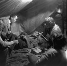 Director of "The Treasure of the Sierra Madre" John Huston (L) with the film's actors Humphrey Bogart (C), his father Walter Huston and two unident. others as they talk inside of lamplit tent.