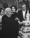 Actor/Director Charlie Chaplin (fore) cutting cake while wife Oona, Sophia Loren and son Sydney look on during 77th birthday party on set of his film "A Countess from Hong Kong."