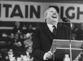 British Tory Leader Edward Health laughing at the microphone during the annual convention of the Conservative Party.