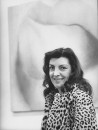 Art dealer Iris Clert in front of Harold Stevenson painting at her Paris art gallery.