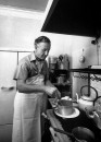British mystery writer Ian Fleming cooking in his apartment.