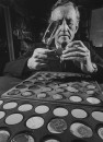 British mystery writer Ian Fleming inspecting old Brazilian coins, magnifying glass ready.