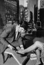 Salesman at the Pines Sane Salon in Paris France fitting a woman for a shoe.