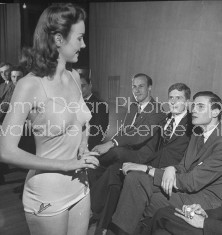 A contestant displaying her charms to the three Lampoon editors.