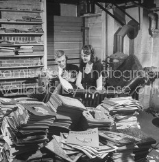 Two students reading stacks of publications from Harvard.