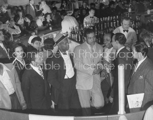 Boxer Joe Louis talking with patrons at his restaurant.