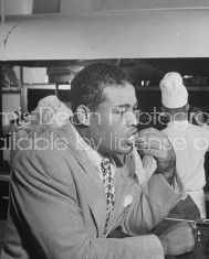 Boxer Joe Louis eating in the kitchen at his restaurant.