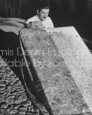 A man working with hand blocked fabrics made by tillets.