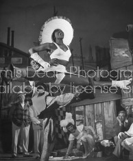 Two members of the chorus the play "Beggar's Holiday" performing gymnastics.