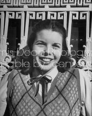 Co-ed student wearing ribbon tie, adding favorable touch to white blouse.