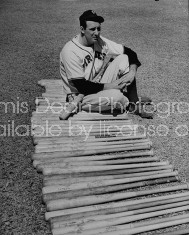 Pittsburg Pirates baseball player Hank Greenberg sitting by long row of bats on ground.