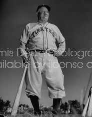 Pirates baseball player Honus Wagner standing and holding baseball bat.