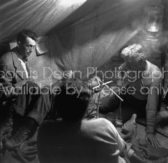 Director of "The Treasure of the Sierra Madre" John Huston (L) with the film's actors Humphrey Bogart (C, lying down) and his father Walter Huston as they talk inside of lamplit tent.
