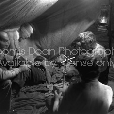 Director of "The Treasure of the Sierra Madre" John Huston (L) with the film's actors Humphrey Bogart (C, lying down), his father Walter Huston and two unident. others as they talk inside of lamplit tent.