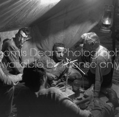 Director of "The Treasure of the Sierra Madre" John Huston (L) with the film's actors Humphrey Bogart (C), his father Walter Huston and two unident. others as they talk inside of lamplit tent.