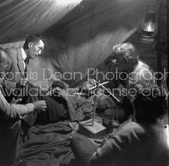 Director of "The Treasure of the Sierra Madre" John Huston (L) with the film's actors Humphrey Bogart (C), his father Walter Huston and two unident. others as they talk inside of lamplit tent.