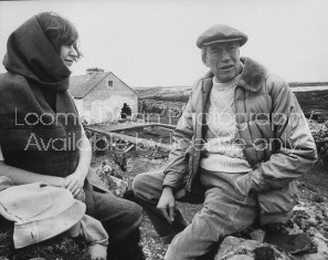 Actor/Director John Huston (R), sitting outside near his home with a female member of his family.