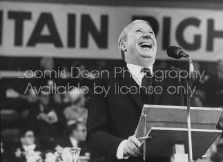 British Tory Leader Edward Health laughing at the microphone during the annual convention of the Conservative Party.