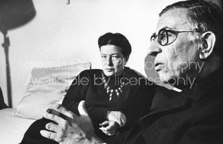 Writer Simone de Beauvoir chatting with close friend, playwright Jean Paul Sartre in her Paris apartment.