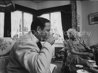 Actress Margaret Rutherford (R) having tea with a local minister.