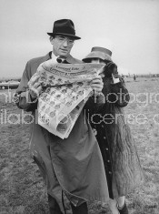 Actor Gregory Peck and his wife, reading the newspaper before Grand National race.