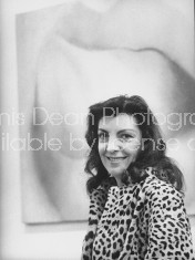 Art dealer Iris Clert in front of Harold Stevenson painting at her Paris art gallery.