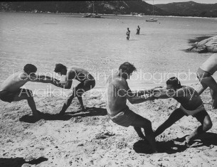Members of French vacation Club Mediterranee doing exercises on beach.