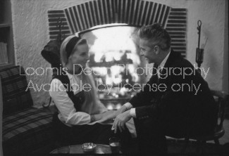 Conductor Herbert von Karajan (R) and wife Eliette, sitting in front of a fireplace; prob. Salzburg.  [Scanned from contact sheet.]